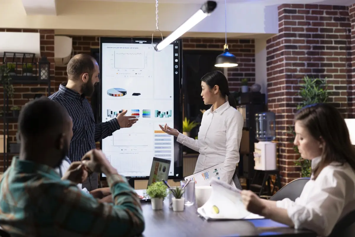 Team discussing data and charts during a project management training session at a professional Project Management Institutes in Qatar